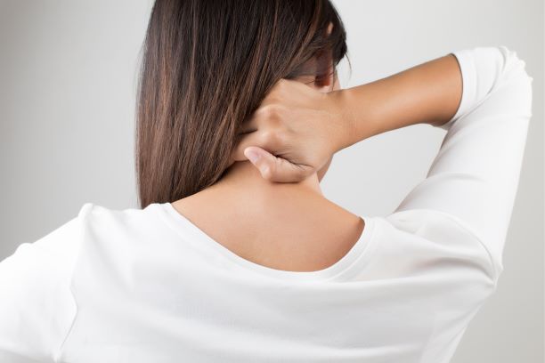 Woman holding the back of her neck, as if in pain